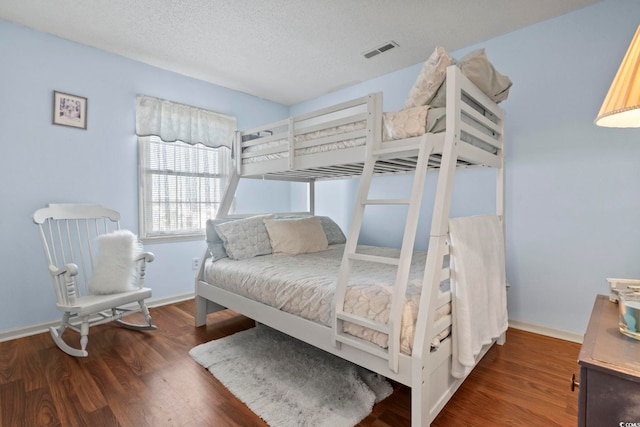702 Plantation Dr, Surfside Beach, SC 29575 - bedroom with wood finished floors, baseboards, and a textured ceiling