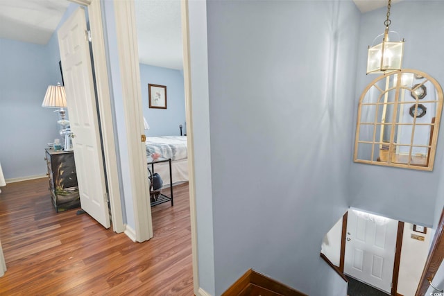 hallway featuring dark hardwood / wood-style floors and a notable chandelier