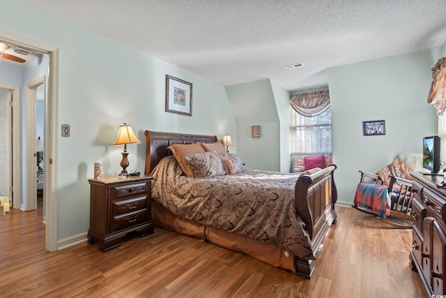 702 Plantation Dr, Surfside Beach, SC 29575 - bedroom with wood finished floors, a textured ceiling, and baseboards