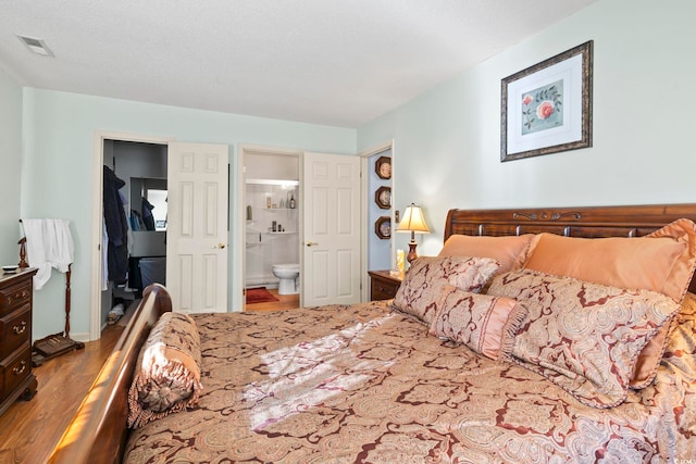 bedroom featuring hardwood / wood-style flooring and connected bathroom