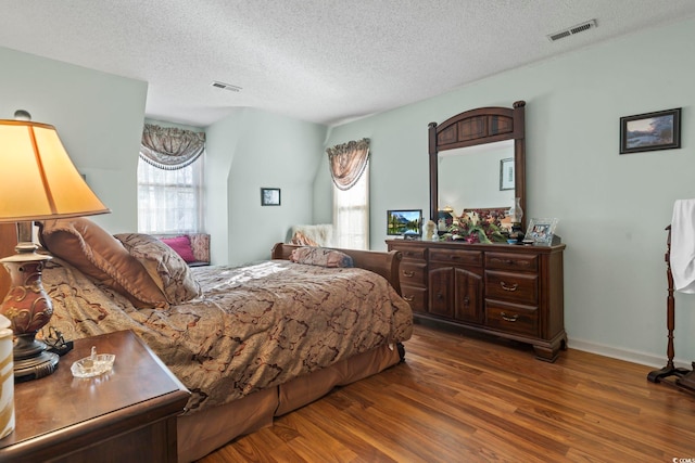 702 Plantation Dr, Surfside Beach, SC 29575 - bedroom featuring wood finished floors, a textured ceiling, and baseboards