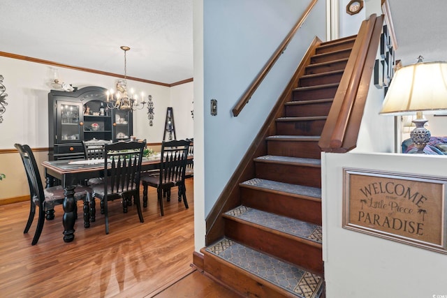 702 Plantation Dr, Surfside Beach, SC 29575 - staircase with a chandelier, wood finished floors, and crown molding