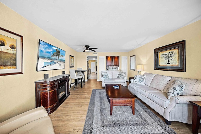 living room featuring ceiling fan and light wood-type flooring