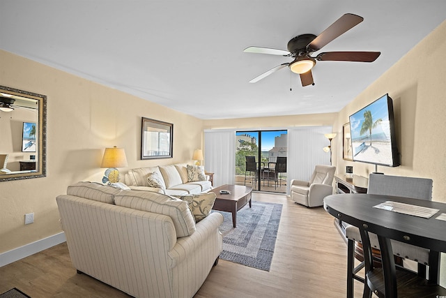 living room with ceiling fan and light hardwood / wood-style flooring