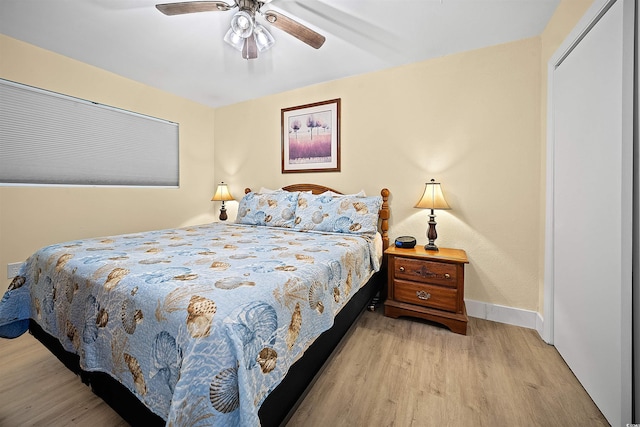 bedroom with ceiling fan, light wood-type flooring, and a closet