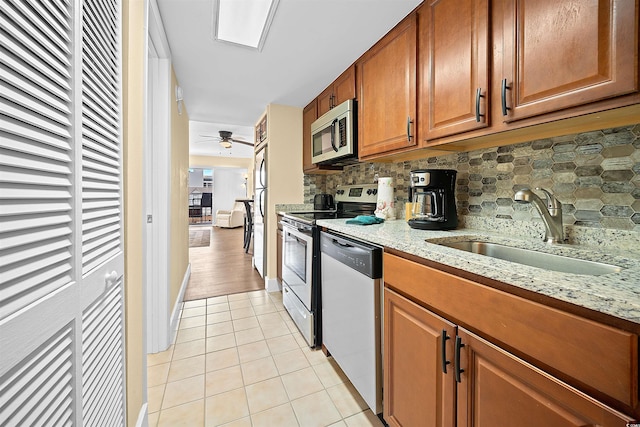 kitchen with ceiling fan, sink, stainless steel appliances, tasteful backsplash, and light tile patterned floors