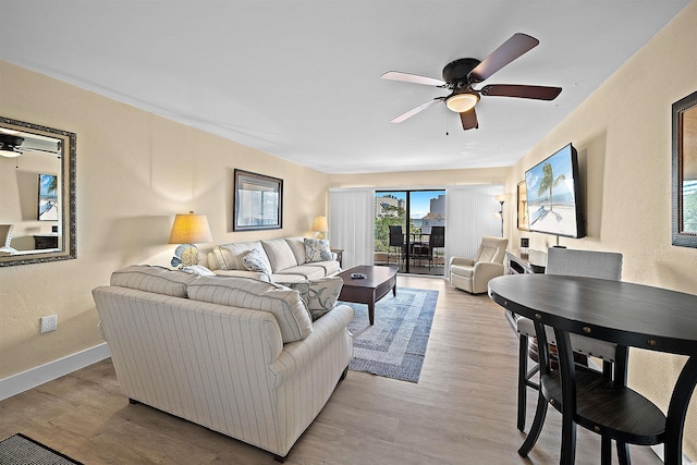 living room with ceiling fan and light hardwood / wood-style flooring