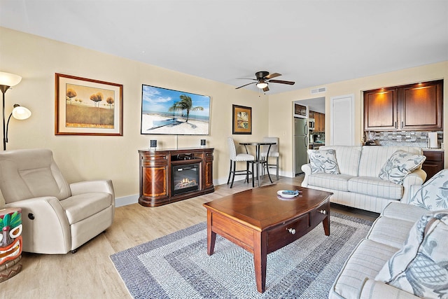 living room with ceiling fan and light hardwood / wood-style floors