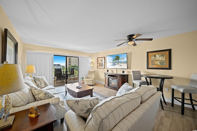 living room featuring light hardwood / wood-style flooring and ceiling fan