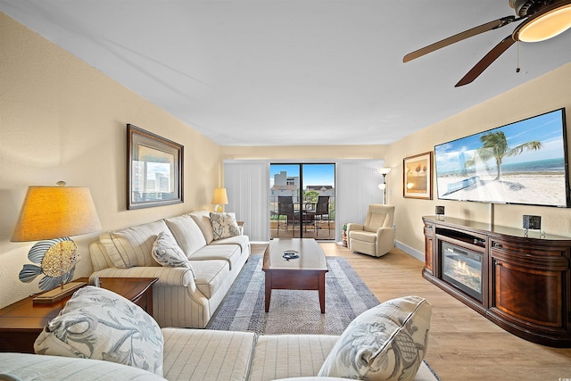 living room with ceiling fan and light hardwood / wood-style floors