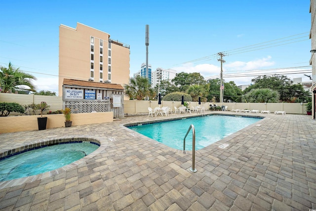 view of swimming pool featuring a patio and a hot tub