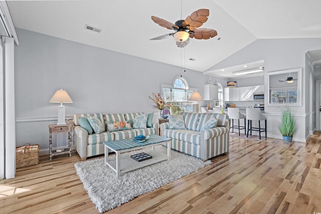 living room featuring light wood-type flooring, high vaulted ceiling, and ceiling fan