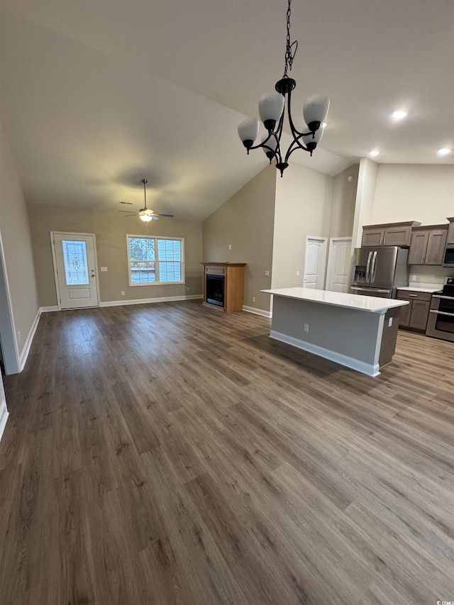 kitchen with a center island, stainless steel appliances, dark hardwood / wood-style floors, lofted ceiling, and ceiling fan with notable chandelier