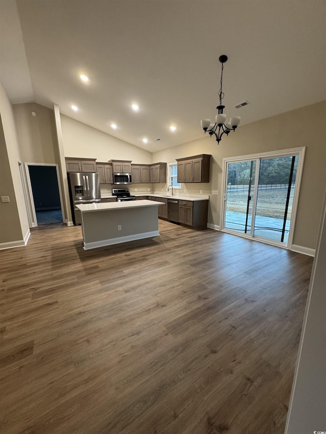 kitchen featuring decorative light fixtures, a center island, dark hardwood / wood-style flooring, and an inviting chandelier