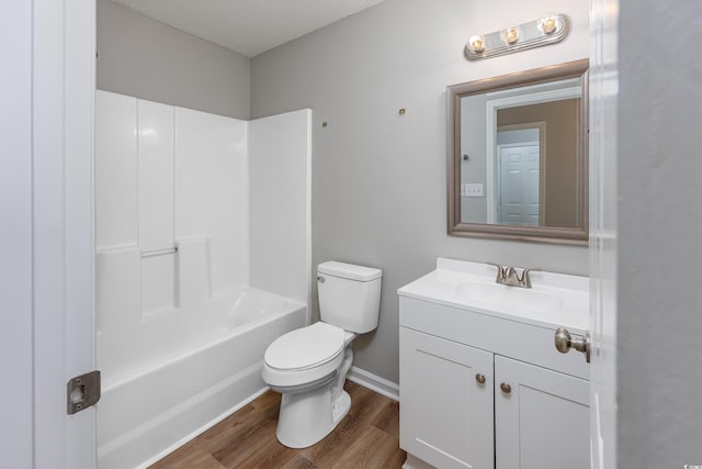 full bathroom with vanity, hardwood / wood-style flooring, toilet, and washtub / shower combination