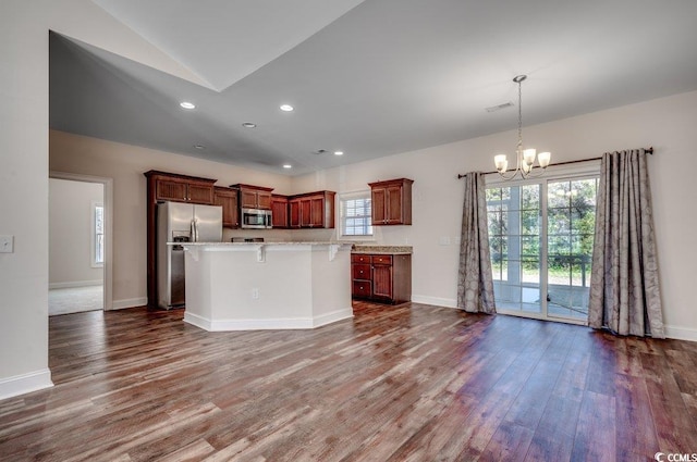 kitchen featuring stainless steel appliances, a kitchen island, dark wood-type flooring, and a notable chandelier