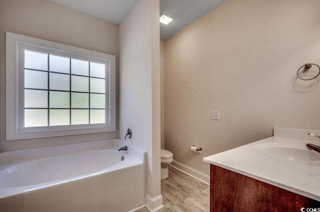 bathroom featuring vanity, a bath, and toilet