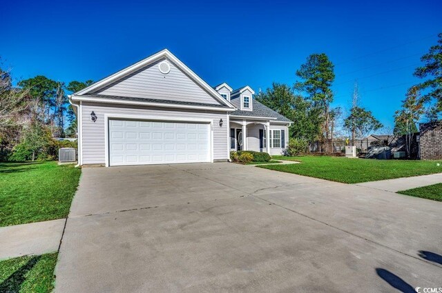 view of front of house with a garage, central AC unit, and a front yard