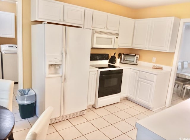 kitchen featuring white cabinets, washer / dryer, white appliances, and light tile patterned floors