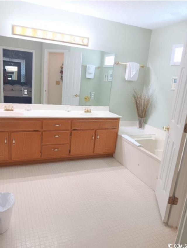 bathroom featuring vanity, a healthy amount of sunlight, and a bath