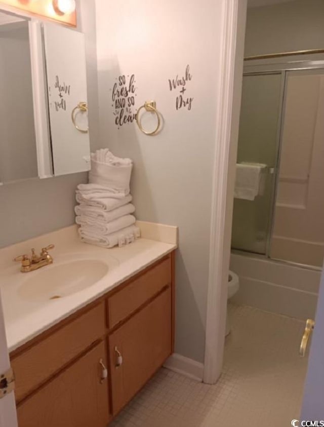 full bathroom with shower / bath combination with glass door, tile patterned flooring, vanity, and toilet