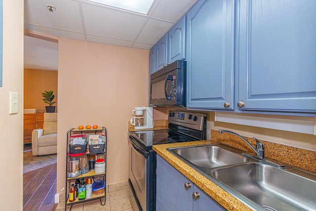 kitchen featuring stainless steel range with electric stovetop, a paneled ceiling, and blue cabinets