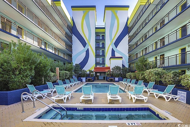 view of pool with a hot tub