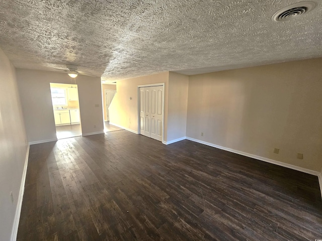 spare room with ceiling fan, dark hardwood / wood-style flooring, and a textured ceiling