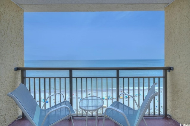 balcony featuring a water view and a beach view