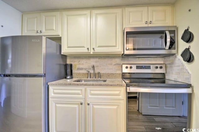 kitchen with dark hardwood / wood-style flooring, sink, stainless steel appliances, and tasteful backsplash