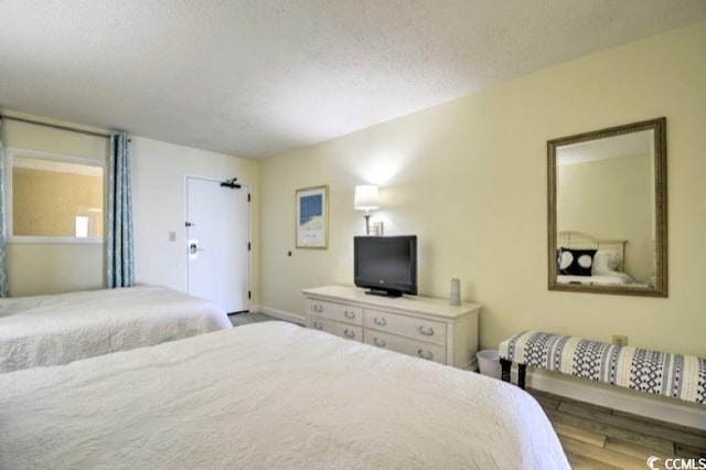 bedroom with light hardwood / wood-style floors and a textured ceiling