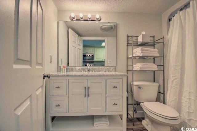 bathroom with curtained shower, vanity, a textured ceiling, and toilet