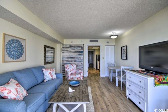 living room with a textured ceiling and hardwood / wood-style flooring