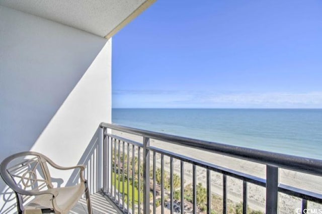 balcony featuring a view of the beach and a water view