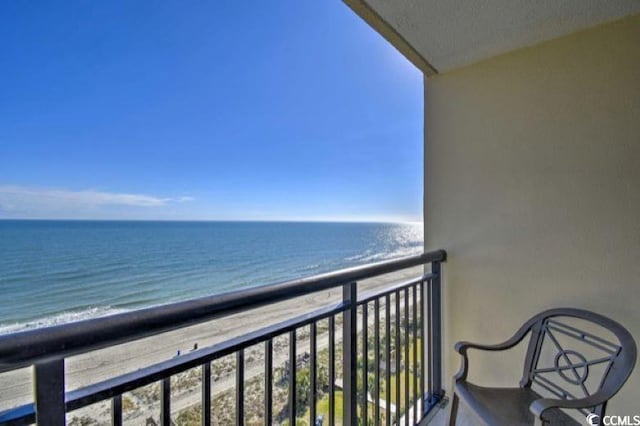 balcony featuring a water view and a view of the beach