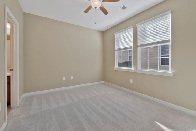 spare room featuring light colored carpet and ceiling fan