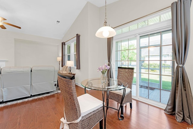 dining area featuring ceiling fan, wood-type flooring, and lofted ceiling