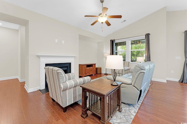 living room with wood-type flooring, ceiling fan, and lofted ceiling