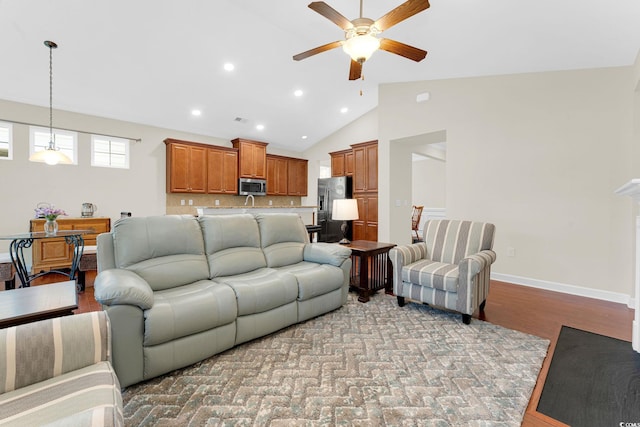 living room with light wood-type flooring, ceiling fan, and lofted ceiling