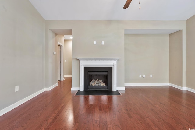 unfurnished living room with ceiling fan and dark wood-type flooring