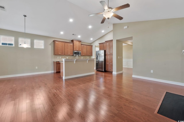 kitchen featuring a kitchen breakfast bar, ceiling fan, decorative light fixtures, a kitchen island, and stainless steel appliances