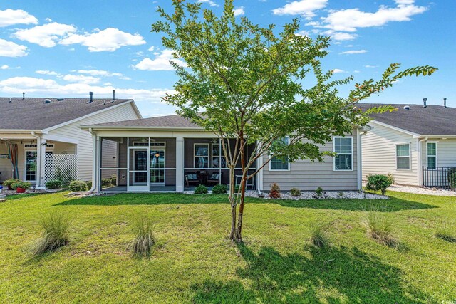 back of house featuring a yard and a sunroom