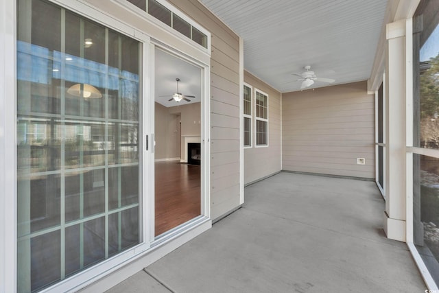 unfurnished sunroom with ceiling fan