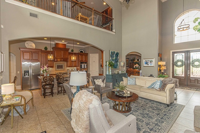 living room featuring visible vents, french doors, arched walkways, crown molding, and light tile patterned floors