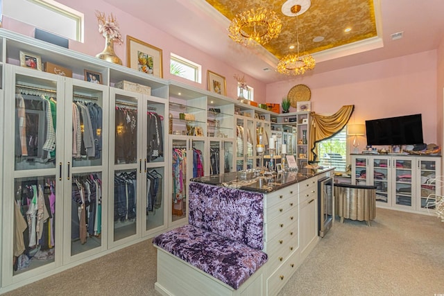 walk in closet with a raised ceiling, beverage cooler, and carpet floors