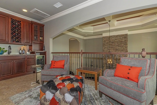 living area with visible vents, ornamental molding, coffered ceiling, wine cooler, and wet bar