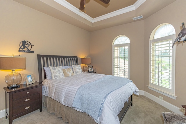 bedroom with visible vents, crown molding, baseboards, a tray ceiling, and carpet flooring