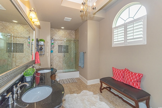 bathroom with double vanity, visible vents, baseboards, and a sink