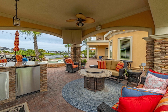 view of patio with an outdoor kitchen, an in ground hot tub, outdoor lounge area, and ceiling fan