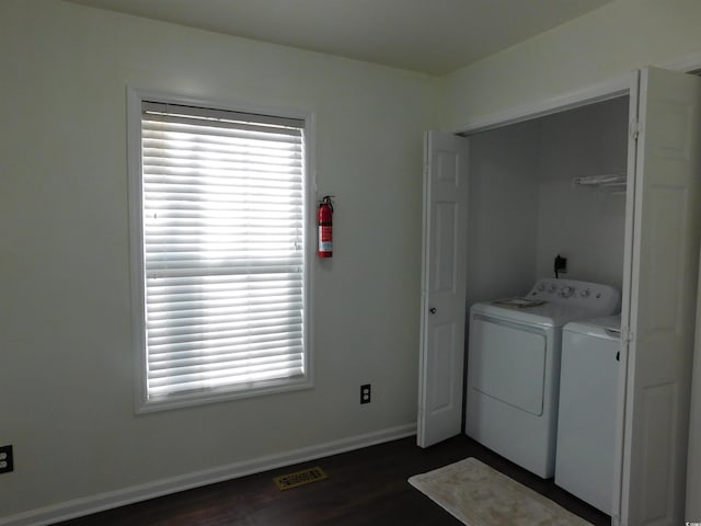 clothes washing area featuring dark hardwood / wood-style flooring and washing machine and dryer